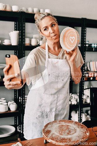 Image of Happy woman, pottery and selfie in small business for social media, advertising or fun vlog at store. Female person or retail owner with tongue out and clay bowl for funny photo or post on smartphone