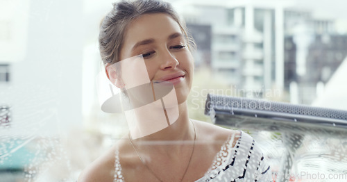 Image of Woman, face and cleaning window with foam and detergent, chemical liquid and housekeeping with focus. Female cleaner with soap, clean glass and disinfectant with hygiene, housekeeper and maintenance