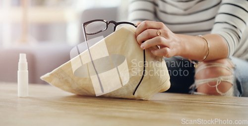 Image of Hand, woman cleaning glasses and spray with chemical liquid, cloth and hygiene with lens maintenance. Clean spectacles, eyewear and female cleaner at home with eye care and disinfectant bottle