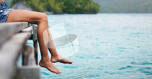 Image of Feet, lake and travel with a woman outdoor on a calm deck to relax with peace, water and mockup space. Female person with Africa tattoo on legs and freedom on vacation, holiday or adventure in nature