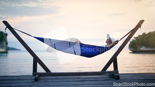 Image of Hammock, sunset ocean and woman relax outdoor on a vacation, holiday or adventure in nature. Female person on tropical trip, travel and deck with sea, sky and water in summer for zen, peace and calm