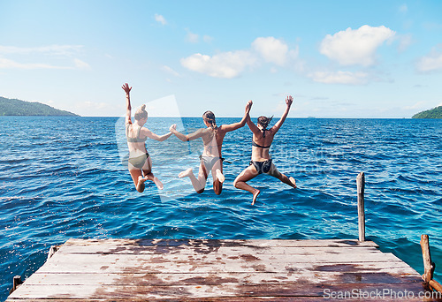 Image of Water, back of people jumping off a pier holding hands and into the ocean together in blue sky. Summer vacation or holiday break, freedom or travel and young group of friends diving into the lake