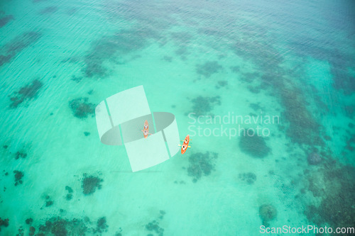 Image of Aerial boat and people in ocean for kayak adventure, travel or journey at sea together in the outdoors. Couple traveling, kayaking or rowing on big calm, peaceful or serene beach water in nature