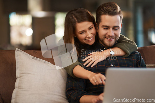 Image of Relax, laptop and social media with a couple on a sofa in the living room of their home together. Computer, web or internet with a man and woman hugging while bonding in their house on the weekend