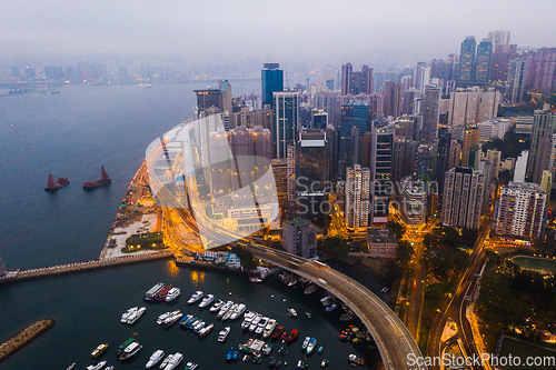 Image of Buildings, ocean and aerial view of the city at night with lights, boats and ships on the sea harbor. Landscape, architecture and drone of an urban town with skyscrapers, yachts and infrastructure.