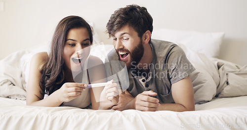 Image of Happy couple on bed, surprise and pregnancy test, shock and excited for future family, life, love and happiness. Positive results, man with pregnant woman in bedroom and good news in home together.