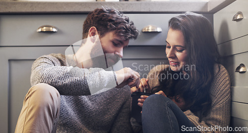 Image of Ice cream, relax and couple on floor in kitchen for bonding, relaxing and quality time together. Love, relationship and man and woman sharing sweet treats, dessert and luxury snack for romance date