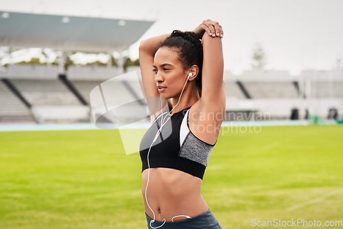 Image of Woman, fitness and stretching arms on stadium track for running, exercise or workout. Active female person or athlete in warm up body stretch for sports training, athletics or cardio run outdoors