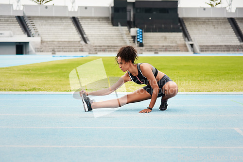 Image of Woman, fitness and stretching body on stadium track for running, exercise or workout. Active female person or athlete in warm up leg stretch for sports training, athletics or cardio run outdoors