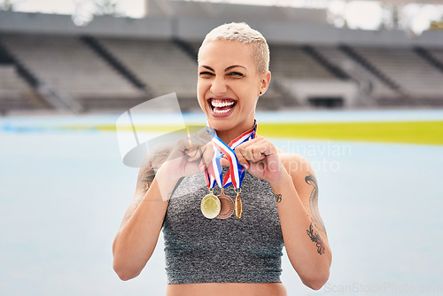 Image of Portrait, success medals and woman athlete at stadium after winning race or sports event outdoors. Fitness, winner and female runner happy with victory, goals or target achievement on track field.