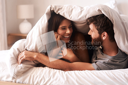Image of Blanket, relax and couple with love, home and comfortable with joy, romance and loving together. Partners, man and happy woman in the bedroom, happiness and peace with a smile, romantic and bonding