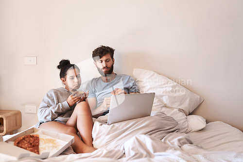 Image of Hungry couple, pizza and movie on laptop in bed with junk food and streaming series. Eating, computer video and meal in a bedroom at home with man and woman with bonding, online watching and mockup