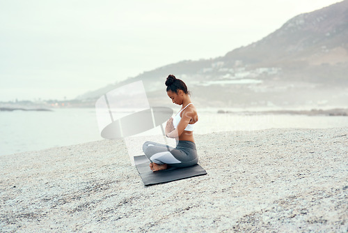 Image of Yoga, calm meditation and woman on a beach with lotus pose, wellness and fitness. Pilates, sea and female person on sand with peace in nature feeling relax with spiritual and ocean exercise alone