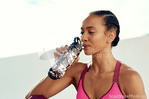 Image of Fitness, woman and drinking water on break after workout, exercise or training outdoors. Sports, nutrition or thirsty female person in rest with drink, diet or minerals for natural sustainability