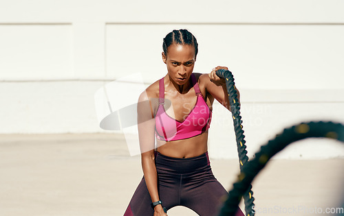 Image of Woman, fitness and battle rope exercise for physical workout, training or wellness in the outdoors. Fit, active or serious female person exercising with ropes for intense endurance, stamina or cardio