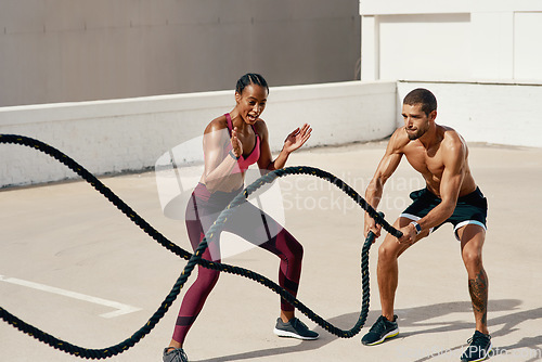 Image of Woman, personal trainer and battle rope for workout, exercise or training in fitness outdoors. Fit, active or serious coaching with man person exercising with ropes for sports endurance or motivation