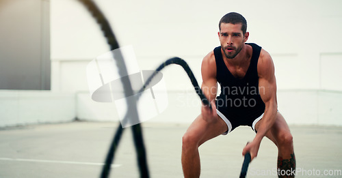 Image of Man, fitness and battle ropes in training, exercise or workout for physical wellness outdoors. Fit, active and serious male person exercising with rope for intense body endurance, stamina or cardio