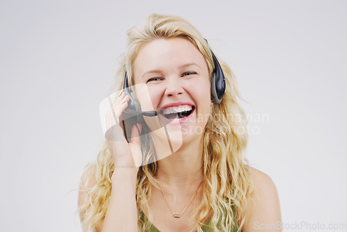 Image of Call center, woman and laugh in studio portrait with headset, smile and excited for tech support by backdrop. Funny agent, telemarketing and customer service with mic, voip and happy for consulting