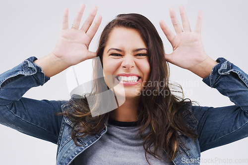 Image of Portrait, funny face and ears with a crazy woman joking in studio on a white background for humor. Comic, comedy and hands with a happy young female person feeling playful while smiling or having fun