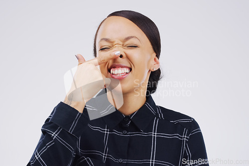 Image of Portrait, funny face and finger on nose with a woman laughing in studio on a white background for humor. Comic, comedy and showing nostrils with a playful young female person joking or having fun