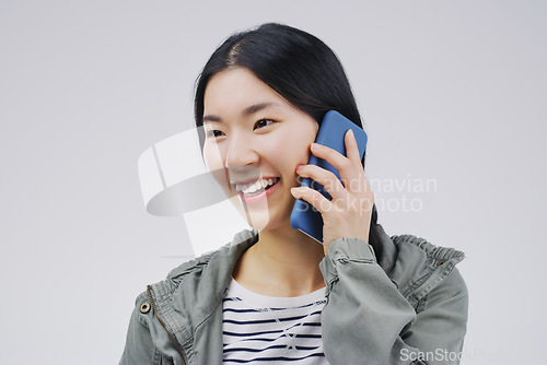 Image of Smile, phone call and Asian woman talking in studio isolated on a white background with mockup. Funny, cellphone and female person speaking, discussion or communication, conversation and networking.