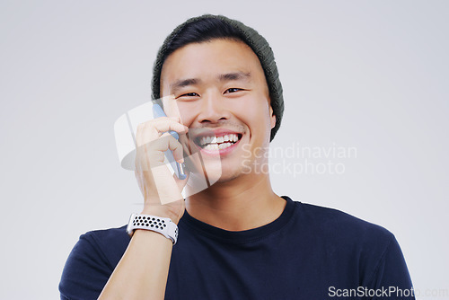 Image of Phone call, funny and portrait of Asian man talking in studio isolated on white background. Cellphone, laughing and face of male person in communication, speaking or discussion, comedy or comic meme.