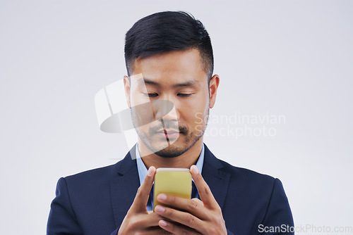 Image of Serious, phone and Asian business man in studio isolated on a white background. Mobile, cellphone and male person typing for email, web scroll or browsing online, social media or internet app to text