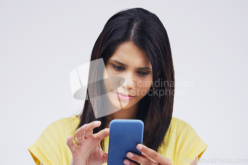 Image of Serious, phone and woman typing in studio isolated on white background for social media. Mobile, cellphone and female person texting, networking or email, web scroll or browsing online messaging app.