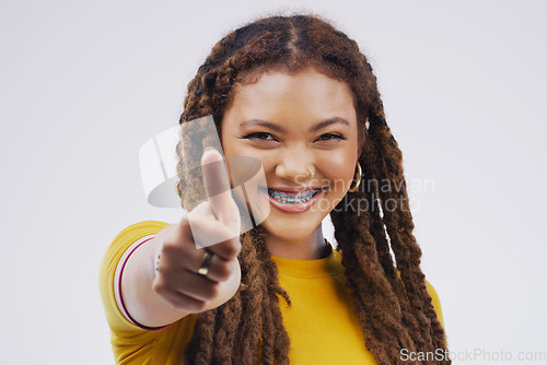 Image of Woman, studio portrait and smile with thumbs up for agreement, vote or hand for review with happiness by background. Girl, model and sign for opinion, yes or thank you for motivation, win and success