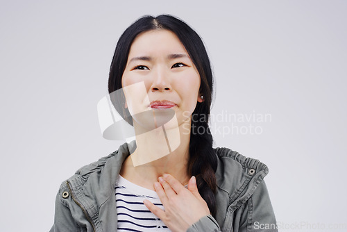 Image of Asian woman, sore throat and virus in pain, allergies or bacteria against a white studio background. Sick Japanese female person touching neck from cough, allergy or flu of cold, illness or infection