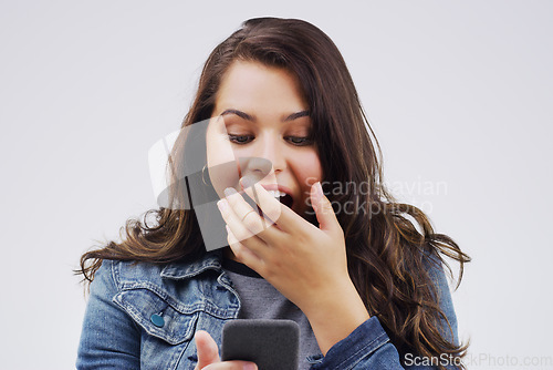 Image of Woman, surprise and phone in shock for winning, prize or good news against a white studio background. Shocked or surprised female person reading on mobile smartphone in wow for lottery competition