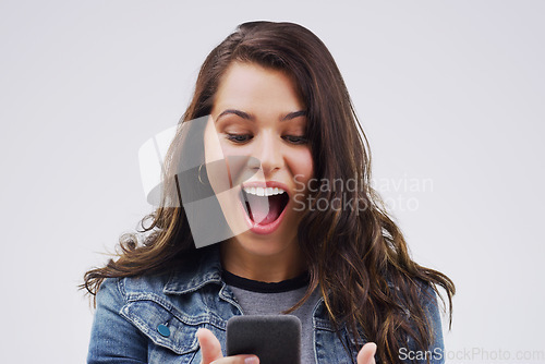 Image of Woman, surprise and phone for winning, prize or good news against a white studio background. Shocked, surprised or excited female person reading on mobile smartphone of lottery winner in wow or bonus