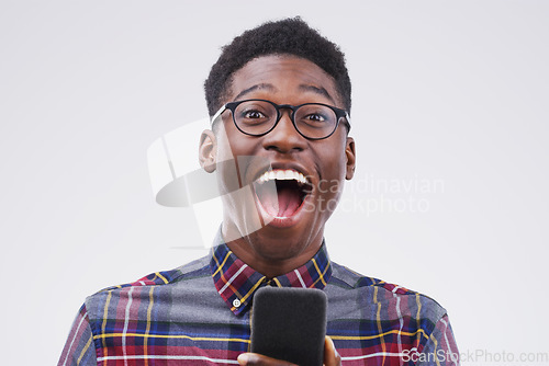 Image of Black man, surprise and phone for winning, prize or good news against a white studio background. Shocked or surprised African male person on mobile smartphone of winner in wow for lottery competition