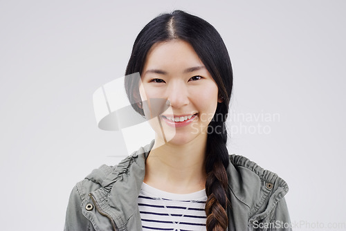 Image of Portrait, happy or smile with an asian woman in studio on white background for japanese fashion. Face, contemporary or style with an attractive young female person looking confident in trendy clothes