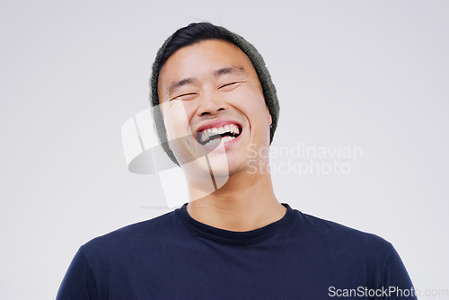 Image of Casual, comedy and man laughing in a studio for joke, comic humor or funny story. Happiness, smile and face of an Asian male person with a positive and joyful facial expression by white background.