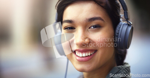 Image of Woman in portrait, headphones in city and smile listening to music, freedom and technology outdoor. Mockup space, podcast or radio streaming with happy female person, urban and audio playlist