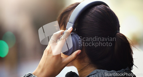 Image of Woman with headphones in city, back view and listen to music, freedom and technology outdoor. Mockup space, podcast or radio streaming with female person in urban street and audio playlist