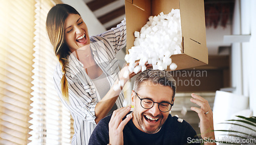 Image of Moving house, real estate and box with a crazy married couple having fun while playing in their new home together. Property, comic or foam with a playful husband and wife joking in the living room