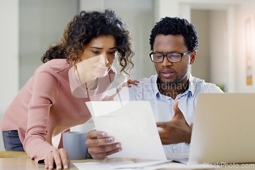 Image of Couple, document and finance for debt, bills or planning expenses together in the kitchen at home. Serious African man and woman working on paperwork in financial crisis, mortgage or investment plan
