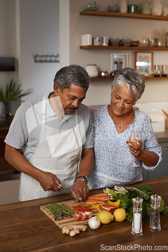Image of Marriage, old man and woman with wine, cooking in kitchen and healthy food, bonding together in home. Drink, glass and vegetables, senior couple with vegetable meal prep and wellness in retirement.