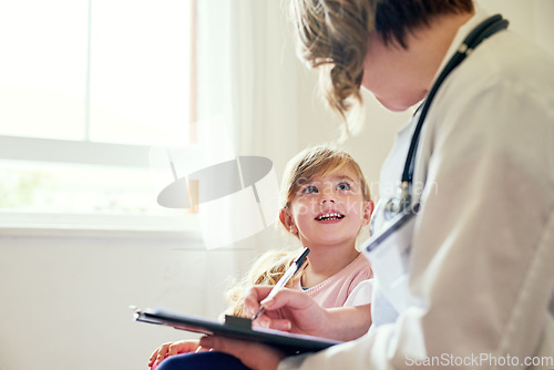 Image of Young girl, doctor and consultation with medical checklist with a smile in a hospital for wellness. Happiness, clinic consultant and pediatrician with healthcare and kids appointment with child form