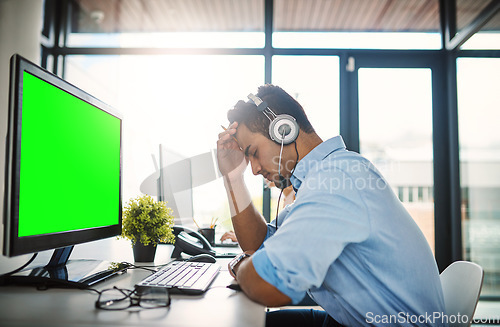 Image of Businessman, call center and headache with green screen computer in burnout, stress or overworked at office. Man consultant agent with bad head pain or anxiety with mockup chromakey at workplace
