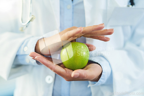 Image of Hands, doctor and nutritionist with apple for nutrition, healthy diet and wellness. Medical professional, hand and woman with fruit for vitamin c, healthcare or natural food for vegan health benefits