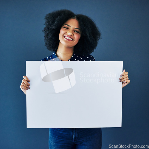 Image of News, mockup and portrait of a woman with a poster isolated on a blue background in studio. Smile, showing and young corporate copywriter with a blank board for branding, design and information space