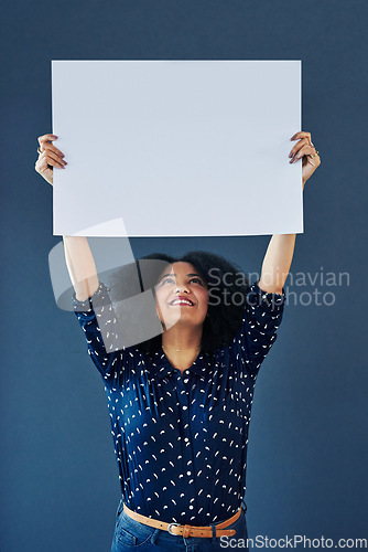 Image of Mockup, poster and happy woman in studio with banner for news, social media or advertising on blue background. Space, billboard and female person with paper, news and branding promotion or launch