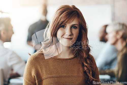 Image of Business, portrait of businesswoman happy and meeting in office at work with coworkers in background. Entrepreneur or creative, lens flare and smiling female worker sitting at workplace in boardroom