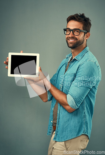 Image of Happy man, tablet and mockup screen for advertising or marketing against a grey studio background. Portrait of male person smiling and showing technology display or copy space for advertisement