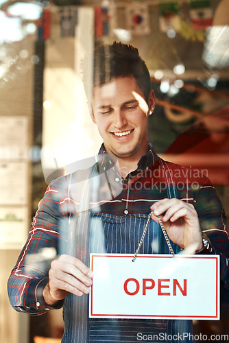 Image of Open sign, happy and man with startup success, entrepreneur and service with restaurant, coffee shop and smile. Male person, employee and business owner with billboard, opening store and welcome