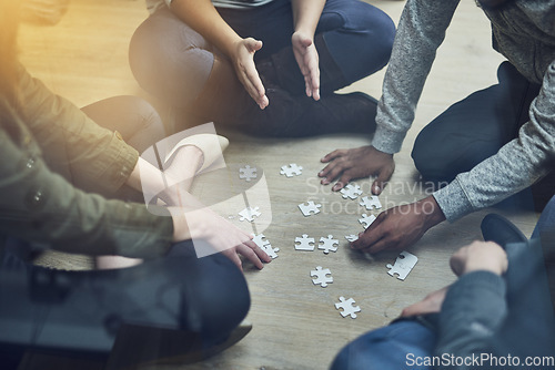 Image of Hands, business people and puzzle in circle, solution and teamwork for problem solving, planning and games. Group, together and innovation with support, synergy and team building on office floor