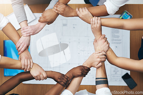 Image of Hands together, above staff and blueprint of people with collaboration and architecture project. Architect team, diversity and paperwork of partnership and teamwork group from above with support